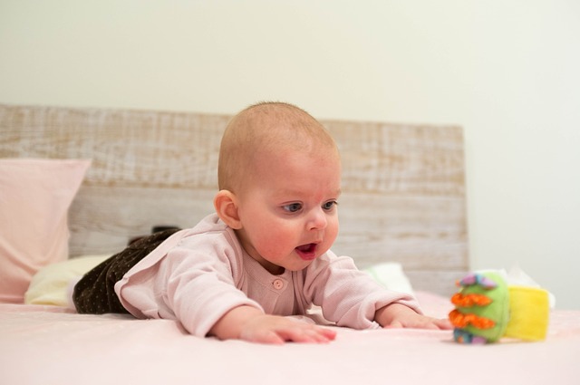 Baby streckt sich nach dem Spielzeug