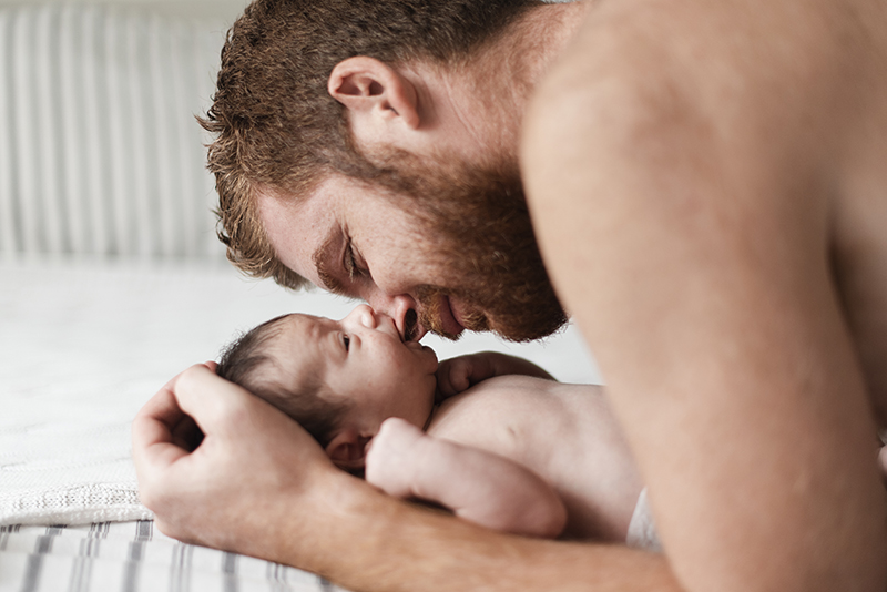 Vater und Baby auf dem Bett